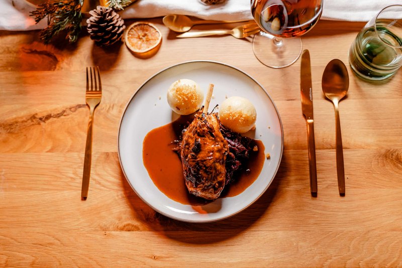 Vegane Keule von MOJEWA mit Knödeln und Jus auf dem gedeckten Festtisch